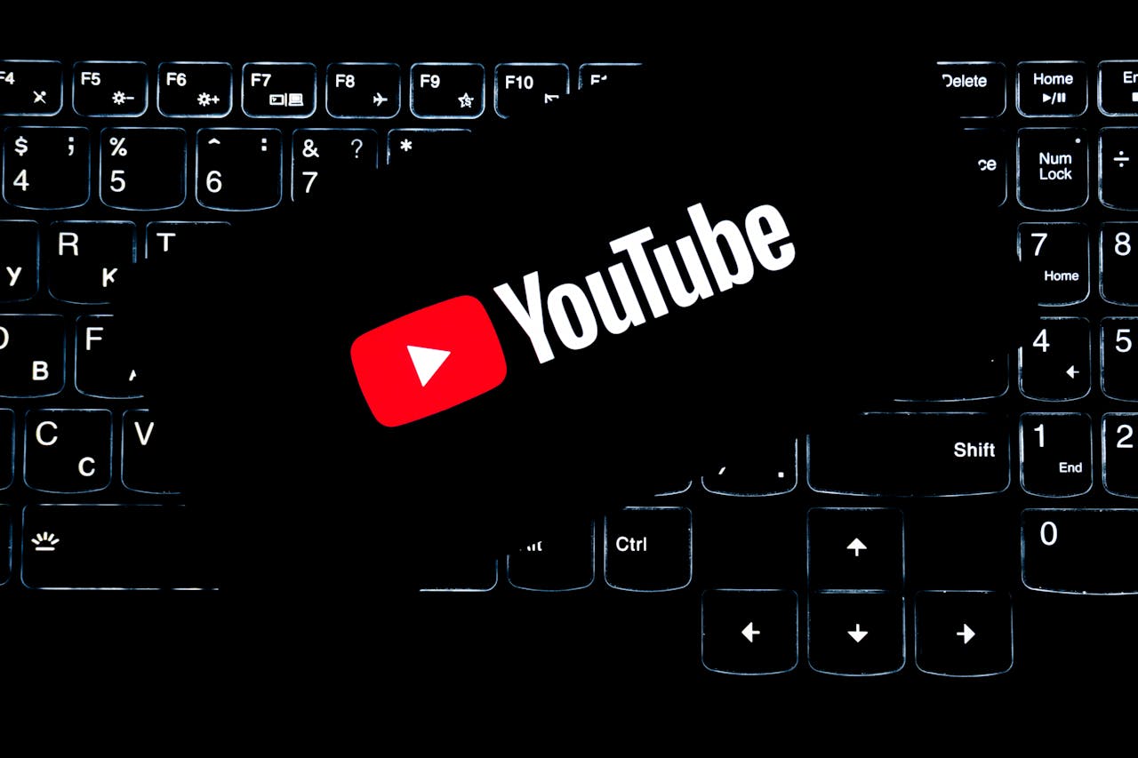 YouTube logo displayed on a backlit keyboard, representing digital media and online content creation.